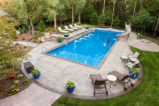 large swimming pool and concrete patio in backyard