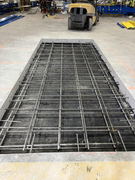 Concrete slab form with steel rebar reinforcement grid prepared for pouring inside an industrial building