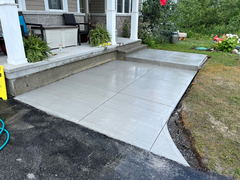 Newly poured brushed concrete porch steps and walkway with clean control joints leading to a front porch.