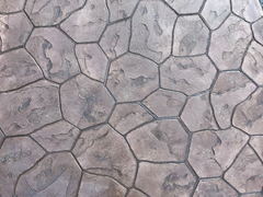 Brown stamped concrete surface with irregular stone pattern and textured finish