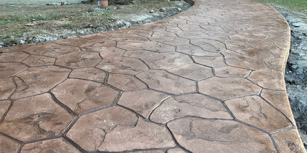 stamped concrete walkway random stone pattern in reddish brown