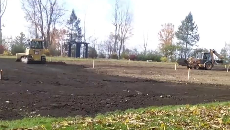 bulldozer and backhoe spreading new soil
