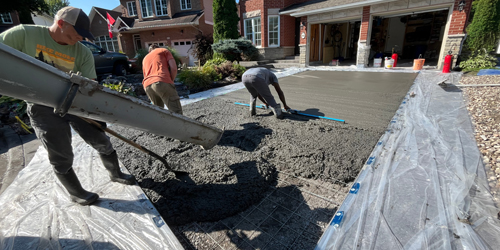 pouring concrete into forms in front yard