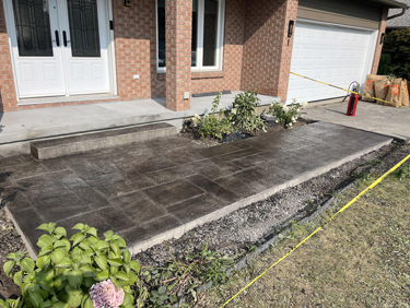 black and grey coloured stamped concrete front walkway